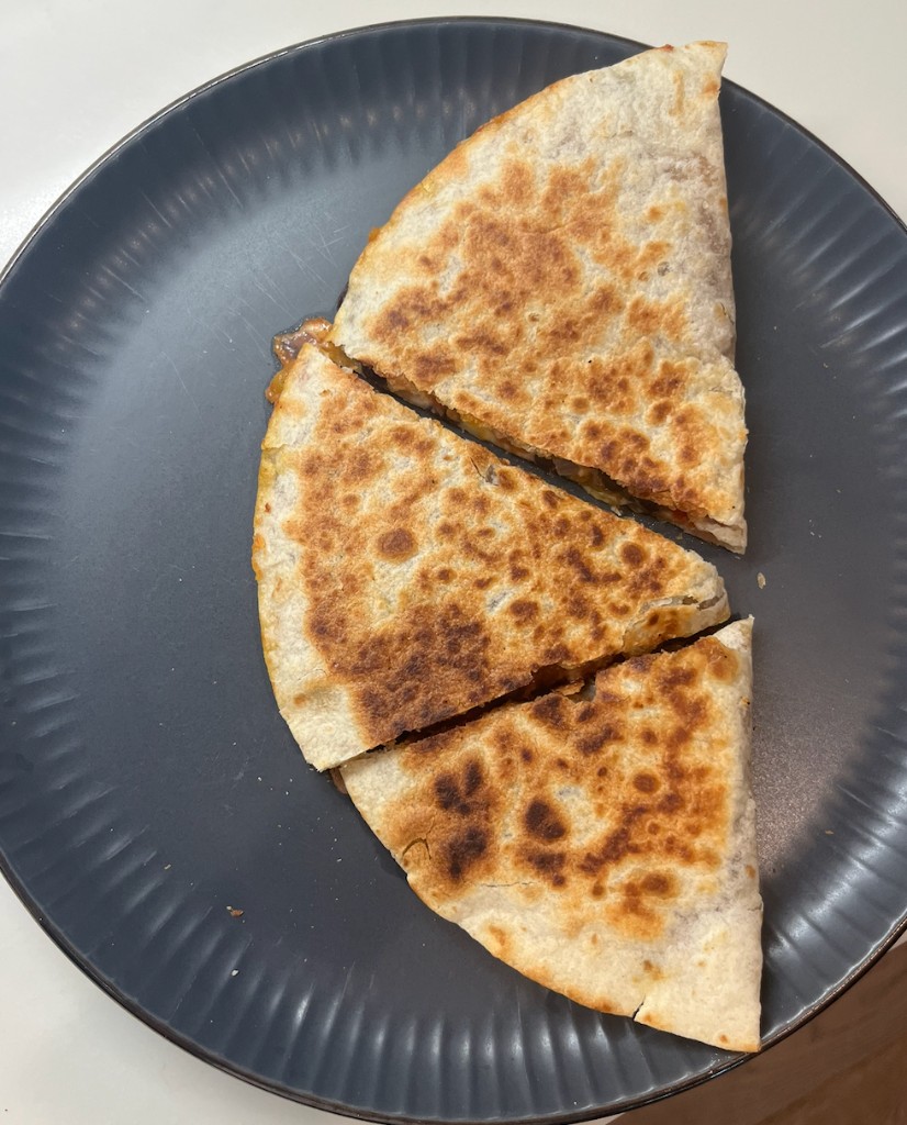 Bean and cheese veggie quesadilla cut into wedges on a plate